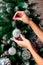 Woman hanging silver Christmas ball on fir tree