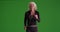 Woman happily fast walking toward the camera with her earbuds in on greenscreen