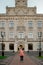 The woman happily raised her arm up standing next to the university