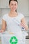 Woman happily throwing bottle into recycling bin