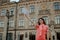 A woman happily waving papers, standing next to the university