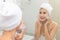 Woman happy cleanses the skin with foam on sink