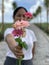 Woman with happy smile and blurry face holding a bouquet of pink roses and daisy flowers in hand. Spread kindness and happiness