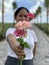 Woman with happy smile and blurry face holding a bouquet of pink roses and daisy flowers in hand. Spread kindness and happiness