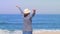 Woman happy smiling joyful with arms up dancing on beach during holidays travel.