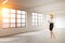 Woman in hardhat in empty room with windows