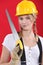 Woman with a hardhat and handsaw