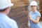 Woman in hardhat next to stack metal