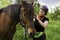 A woman harnesses her horse before riding.