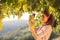 Woman harvesting grapes under sunset light in a vineyard