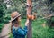 Woman in Hat feeding squirrel in forest