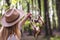 Woman with hat hanging dreamcatcher in woodland