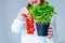 Woman in hat holding herbs of basil and red tomatoes