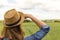 Woman in hat looking over meadow, outdoor activity, hiking, countryside views