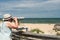 Woman in  hat looks through Coin binoculars at ocean