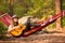 Woman in hat play guitar and relaxing in hammock in middle of forest. Slow life concept.