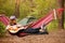 Woman in hat play guitar and relaxing in hammock in middle of forest. Slow life concept.