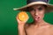 Woman in hat showing juicy citrus