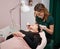 Woman having eyelash extension procedure in beauty salon.