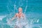 A  woman having fun in the waves of the sea which are splashing her. The beautiful woman mother of three in bikini