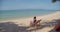 Woman having her morning coffee at beautiful lagoon, she sits on beach alone