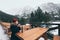 Woman having a hot drink from thermo cup overlooking snowcapped High Tatra mountains peaks