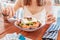 Woman having meal with greek salad Horiatiki in restaurant. Greece cuisine concept