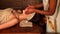 Woman having oil Ayurveda spa treatment. Hands professional masseuse doing facial massage.