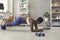 Woman having online fitness class, following trainer& x27;s instructions and doing plank exercise