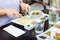 Woman having traditional Israeli breakfast in the morning in cafe. Portion with Eggs omelet, vegetable salad, lemonade, snacks - t