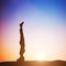 Woman in head stand yoga pose meditating at sunset. Zen