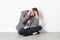 Woman with headache talking on her phone sitting alone at office