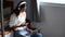 A woman with headphone working online on laptop and using smart phone while sitting on staircase.