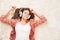 Woman in Headphones Listening Music on Lying on White Carpet, Resting Relaxing Beautiful Happy Girl