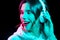 Woman in headphones listening to music in neon