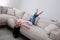 Woman with headphones resting on sofa in living room