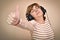 Woman with headphones showing thumb up