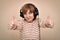 Woman with headphones showing thumbs up