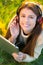 Woman, headphones and tablet in portrait on grass, streaming radio and podcast in outdoors. Happy female person, nature