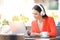 Woman with headphones using a laptop in a coffee shop