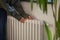 Woman heating hands on home radiator in cold winter season in well-maintained modern building.