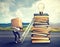 Woman with heavy box climbing the stairs to the top pile of books