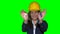 Woman with helmet hold house construction keys. Green chroma background. 4K UHD