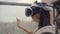 Woman in a helmet of virtual reality against the background of a huge window in the office at the workplace. Architect