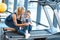 Woman helping girl injured knee sitting on treadmill