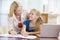 Woman helping girl with laptop doing homework