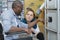 woman helping man in wheelchair next to sports locker