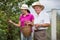 Woman helping an older man in the orchard, to pick blackberries