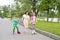 Woman helps children to roller skate in the Park