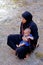 Woman with her baby in the river of The Todra gorges in Morocco
